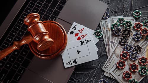 Save Download Preview Online gambling and justice theme, cards, playing chips and judge wooden gavel on laptop keyboard